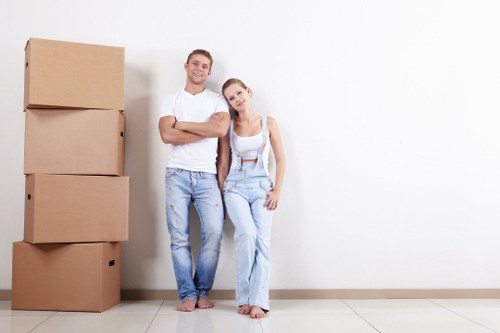 Flat removals team handling furniture in Brixton street setting
